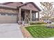 Inviting stone front porch with craftsman columns and fresh landscaping at 15804 Elizabeth Cir, Brighton, CO 80602