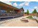 Well-maintained backyard with a covered patio, fire pit, and rock landscaping at 15804 Elizabeth E Cir, Thornton, CO 80602
