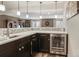 Basement bar area with dark cabinets, quartz countertops, and a wine refrigerator at 15804 Elizabeth E Cir, Thornton, CO 80602