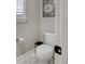 Close up of a powder room with a decorative daisy above the commode and a window with plantation shutters at 15804 Elizabeth E Cir, Thornton, CO 80602