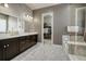 Bathroom featuring dual sink vanity, tile flooring, walk-in closet, shower, and soaker tub at 15804 Elizabeth E Cir, Thornton, CO 80602