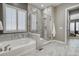 Bathroom featuring a glass shower and a tub beneath a bright window with white shutters at 15804 Elizabeth E Cir, Thornton, CO 80602
