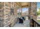 Cozy front porch with comfortable seating, decorative rug, and stone accents, creating a welcoming outdoor space at 15804 Elizabeth E Cir, Thornton, CO 80602
