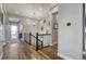 Hallway with wood floors, decorative wall hangings, and a pendant light fixture at 15804 Elizabeth E Cir, Thornton, CO 80602