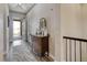 Inviting hallway with wood floors, neutral walls and a vintage-style console table near the front door at 15804 Elizabeth E Cir, Thornton, CO 80602