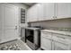 Laundry room with new gray washing machines, granite counters, and storage space at 15804 Elizabeth E Cir, Thornton, CO 80602