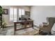 Bright office space featuring a wooden desk, comfortable chair, and large windows with shutters, ideal for productivity at 15804 Elizabeth E Cir, Thornton, CO 80602