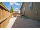 Gravel side yard featuring a wooden fence and gate, with a dog house and storage area at 15804 Elizabeth E Cir, Thornton, CO 80602