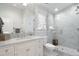 Elegant bathroom features a marble vanity with double sinks, glass shower, and white cabinets at 2475 S Adams St, Denver, CO 80210