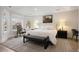 Bright bedroom features a neutral color palette, tray ceilings, large windows, and hardwood floors at 2475 S Adams St, Denver, CO 80210