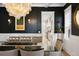 Elegant dining room with a glass table, stylish chandelier, and dark accent wall at 2475 S Adams St, Denver, CO 80210