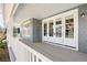 Wraparound porch has gray floors and white railings with multiple glass-paned doors and ample space at 2475 S Adams St, Denver, CO 80210
