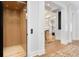 Hallway with elevator, white trim, hardwood floors, and view into the living room at 2475 S Adams St, Denver, CO 80210