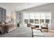 Bright primary bedroom with a sitting area, plush bedding, and large windows at 2475 S Adams St, Denver, CO 80210
