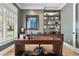 Well-lit office space featuring a custom desk, hardwood floors, built-in shelving, and a view of the outdoors at 2475 S Adams St, Denver, CO 80210