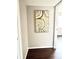 Hallway with artwork, hardwood floors, and an open doorway leading to another room at 18064 E Ohio Ave # 202, Aurora, CO 80017
