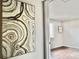 Hallway with artwork, hardwood floors, and an open doorway leading to the bedroom at 18064 E Ohio Ave # 202, Aurora, CO 80017
