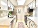 Galley kitchen features white cabinets, modern appliances, and a stylish backsplash at 18064 E Ohio Ave # 202, Aurora, CO 80017