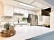 Open kitchen features white cabinets, stainless steel appliances, quartz countertops, and stylish decor at 18064 E Ohio Ave # 202, Aurora, CO 80017