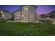 Backyard with large patio, hot tub, grass, and partially fenced yard is illuminated by string lights at dusk at 5286 Rustic Ave, Firestone, CO 80504