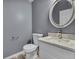 Bathroom features a modern vanity, marble countertop, brushed nickel faucet, and an oval mirror at 5286 Rustic Ave, Firestone, CO 80504