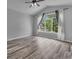 Bright and airy bedroom featuring a large window with backyard views, vaulted ceilings, and hardwood floors at 5286 Rustic Ave, Firestone, CO 80504