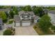 Aerial view of a two-story home boasting an attached three-car garage, and well-manicured landscaping at 5286 Rustic Ave, Firestone, CO 80504