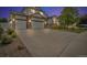 Charming two-story home at twilight with a three-car garage, stone accents, and well-manicured front yard at 5286 Rustic Ave, Firestone, CO 80504