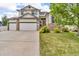 Charming two-story home featuring a three-car garage, stone accents, lush lawn and mature trees at 5286 Rustic Ave, Firestone, CO 80504