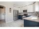 Modern kitchen showcases stainless steel refrigerator, white and navy cabinets, and convenient access to laundry room at 4307 Beautiful Cir, Castle Rock, CO 80109