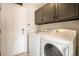 Functional laundry area with modern washer and dryer, ample storage cabinets, and convenient access to the home's entrance at 4307 Beautiful Cir, Castle Rock, CO 80109