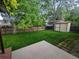 A spacious backyard featuring green grass, mature trees, a wooden fence, and storage shed at 9749 Meade Cir, Westminster, CO 80031