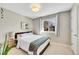 Bright bedroom features a large window, neutral paint, and a bed with a patterned blanket at 9749 Meade Cir, Westminster, CO 80031