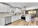 White kitchen with stainless steel appliances, and hardwood floors at 9749 Meade Cir, Westminster, CO 80031