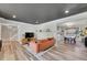 Open-concept living room with wood-look floors, gray ceiling, and seamless access to the dining area at 9749 Meade Cir, Westminster, CO 80031