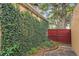 The house is covered in ivy and has a red wooden fence at 1295 S Downing St, Denver, CO 80210