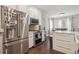 Open kitchen area boasts white cabinets, stainless steel appliances, hardwood floors, and an island at 1295 S Downing St, Denver, CO 80210