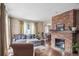 Spacious living room with a brick fireplace, hardwood floors, and natural light at 1295 S Downing St, Denver, CO 80210