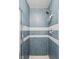 Tiled shower with blue and white trim, a shower head, and a shower caddy for toiletries at 1295 S Downing St, Denver, CO 80210