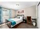 Comfortable bedroom with a window, a bed with stylish linens, and a workspace with a desk and chair at 1391 Elmira St, Aurora, CO 80010