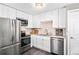 Modern kitchen with stainless steel appliances, white cabinets, and granite countertops at 1391 Elmira St, Aurora, CO 80010