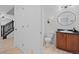 Clean bathroom with classic fixtures, wood cabinet and stylish round mirror at 11935 Riverstone Cir # 6D, Henderson, CO 80640