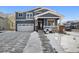 Two-story home with gray siding, brick accents, and a snowy front yard at 3272 Brushwood Dr, Castle Rock, CO 80109