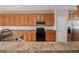 Open kitchen with stainless steel appliances and wood cabinets at 3272 Brushwood Dr, Castle Rock, CO 80109