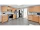 Modern kitchen with stainless steel appliances, wood cabinets, and tile backsplash, leading to laundry area at 2801 Gray St, Wheat Ridge, CO 80214