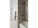 Bathroom featuring gold hardware, sleek gray tiling, and a bathtub with a shower at 7615 E Quincy Ave # 103, Denver, CO 80237