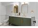 Bathroom featuring double sinks with gold hardware and stylish, chevron-patterned cabinets at 7615 E Quincy Ave # 103, Denver, CO 80237