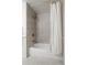Bathroom featuring gold hardware, sleek gray tiling, and a bathtub with a shower at 7615 E Quincy Ave # 103, Denver, CO 80237