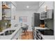 Modern kitchen features white cabinetry, stainless steel appliances, and a dining area at 7615 E Quincy Ave # 103, Denver, CO 80237