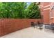 Private brick patio with seating area and lush green trees at 4875 S Monaco St # 107, Denver, CO 80237